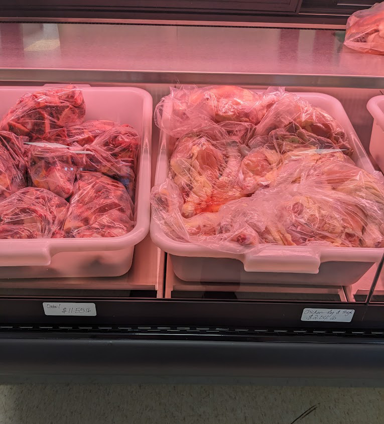 Close up shot of raw oxtail and raw chicken leg and thighs sold at Sunshine Grocers West Indian Store